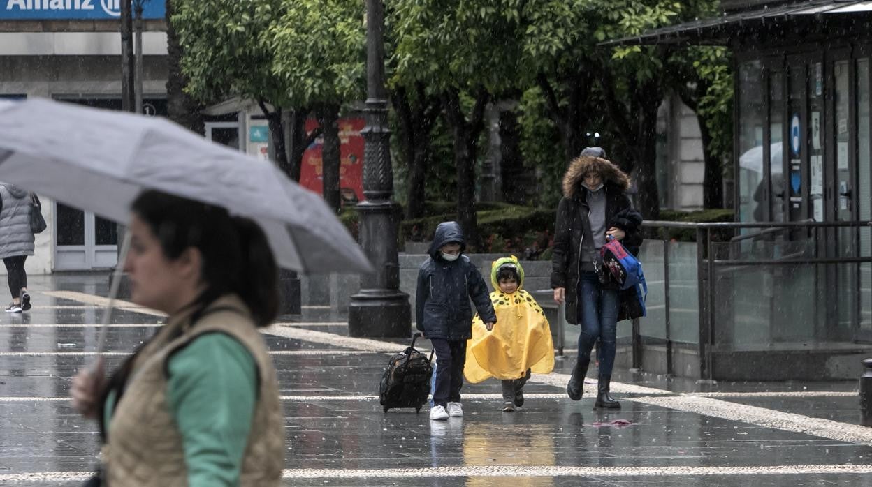 Vecinos en la plaza de Las Tendillas este jueves por la tarde durante una tormenta