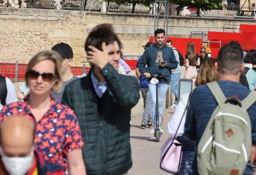 Un joven, ayer transitando por el Puente Romano con su patinete eléctrico