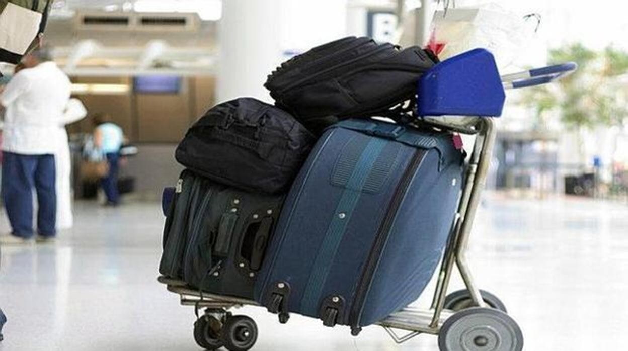 Un carrito cargado con maletas y equipaje, en un aeropuerto