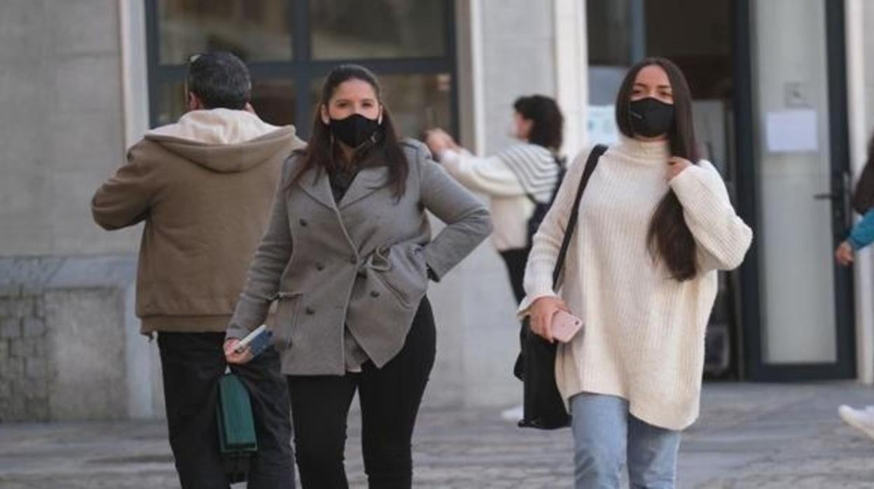 Unas jóvenes con mascarilla por la calle