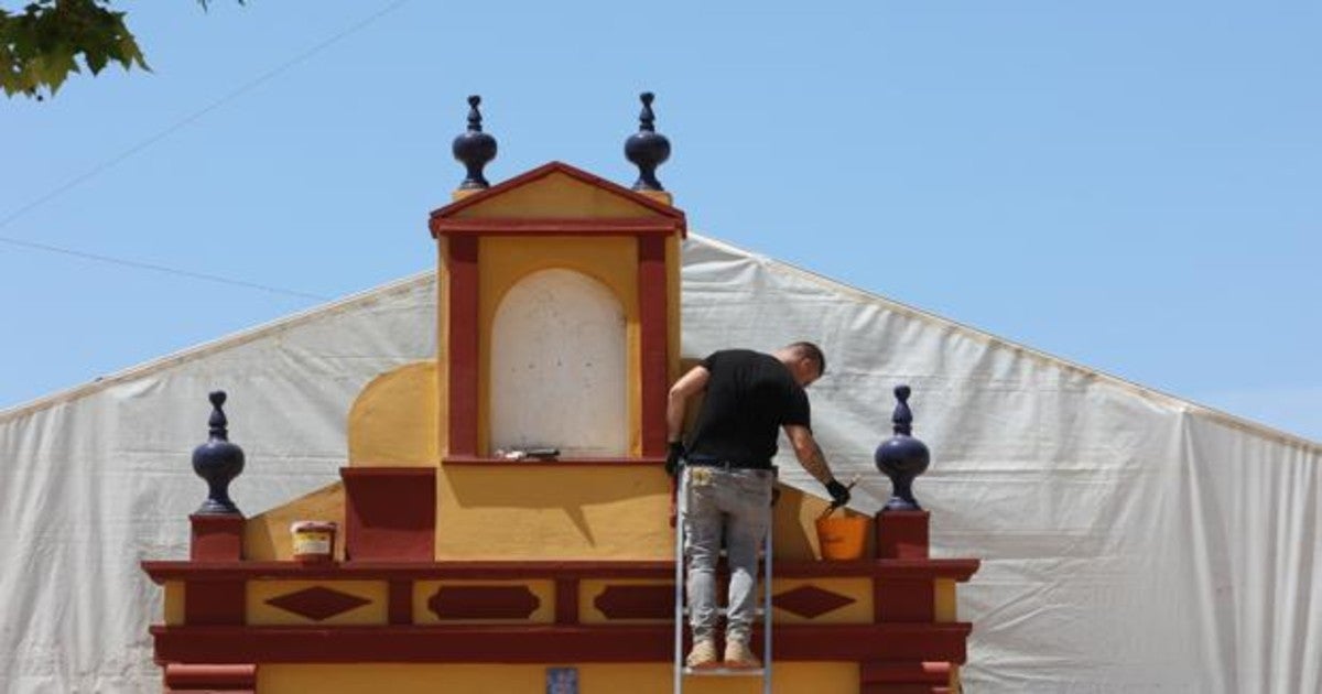 Un operario pinta la portada de una caseta en el recinto ferial del Arenal de Córdoba