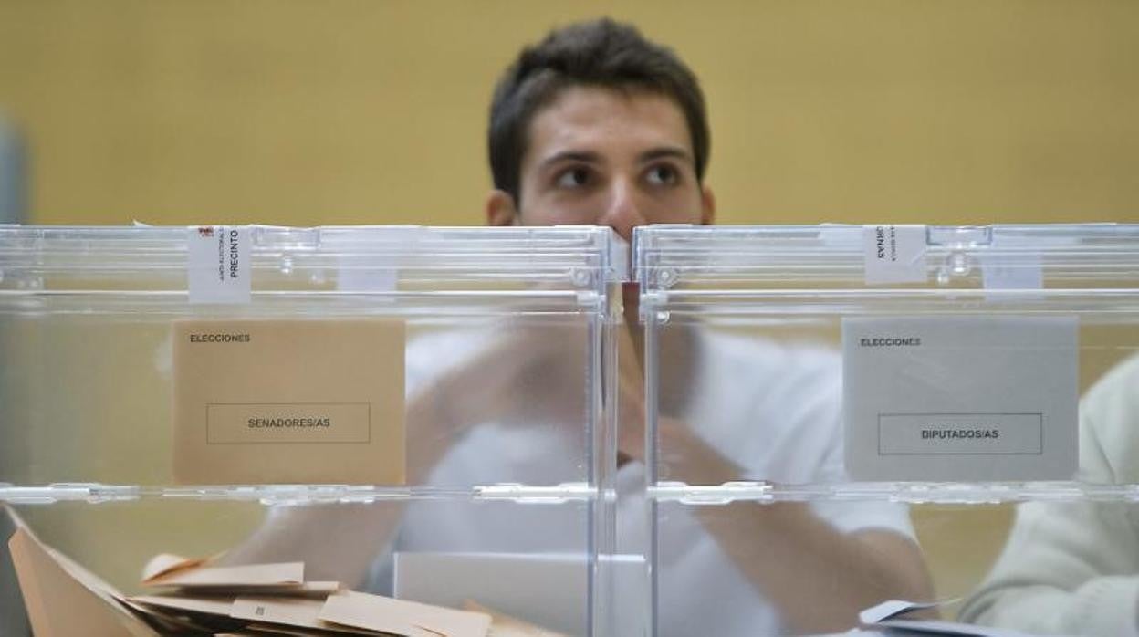 Un joven en una mesa electoral durante los comicios generales de 2011