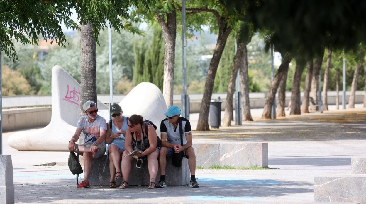 Cuatro personas se protegen del sol y el calor en junio de 2022 en Córdoba