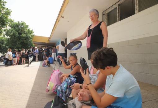 Una buela abanica a su nieta a las puertas del colegio Mediterráneo