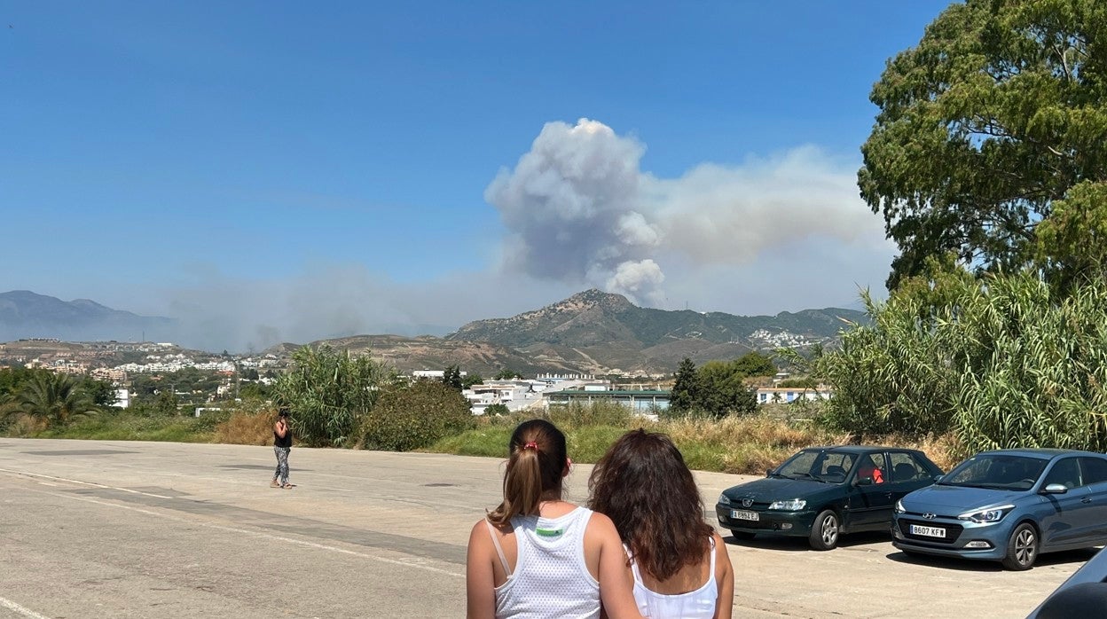 Dos vecinas de Behanavís observaban la columna de humo durante su desalojo en la Carpa de San Pedro en Marbella