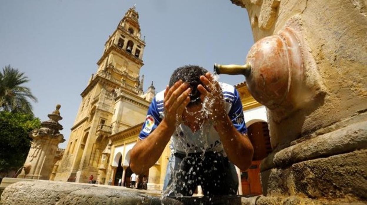 Un hombre se refresca en la fuente del Patio de los Naranjos de la Mezquita de Córdoba