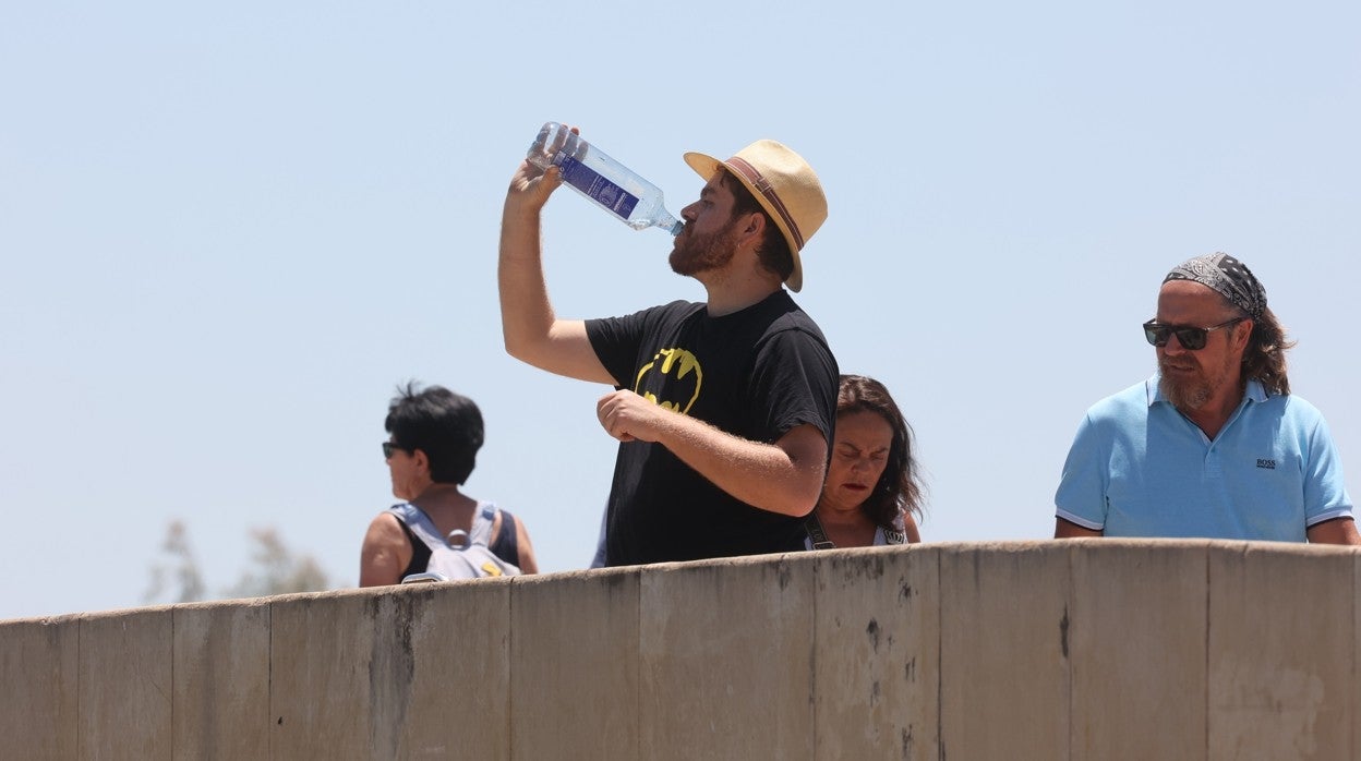 Un hombre se refresca en el Puente Romano de Córdoba