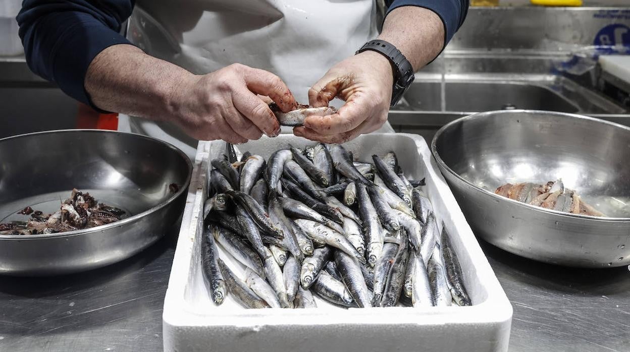 Un pescadero limpia el género en un puesto del mercado de Valencia.