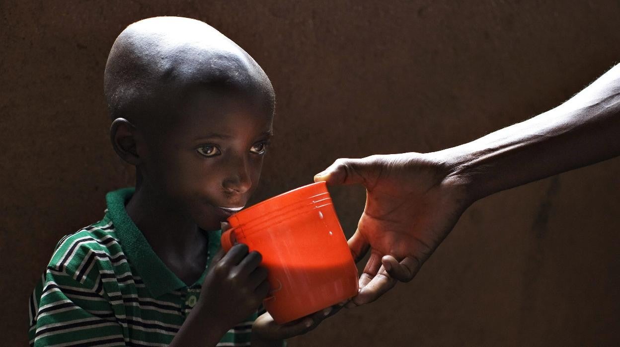 Niño bebe leche en jarra.