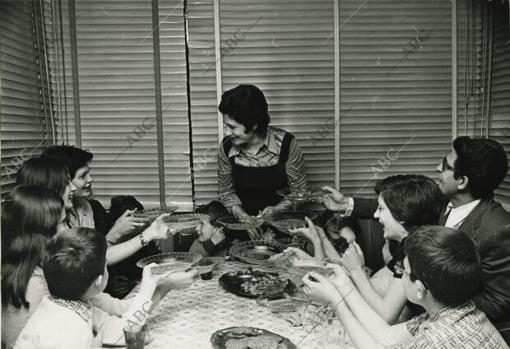 Una familia numerosa sentada a la mesa para comer en 1975