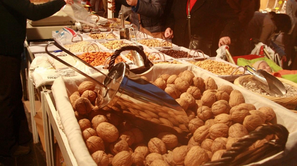 Un puesto de frutos secos, con un cesto de nueces en primer plano