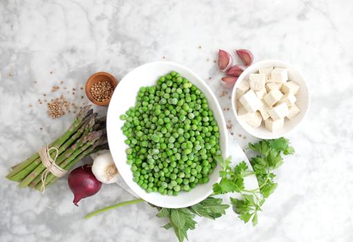 Bodegón de ingredientes para preparar el pesto de guisantes.