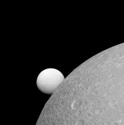 Dione, con Encelado al fondo