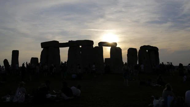 El sol sale tras el monumento de Stonehenge, conocido como «El Templo del Sol», durante el festival del Solsticio de Verano, en Reino Unido