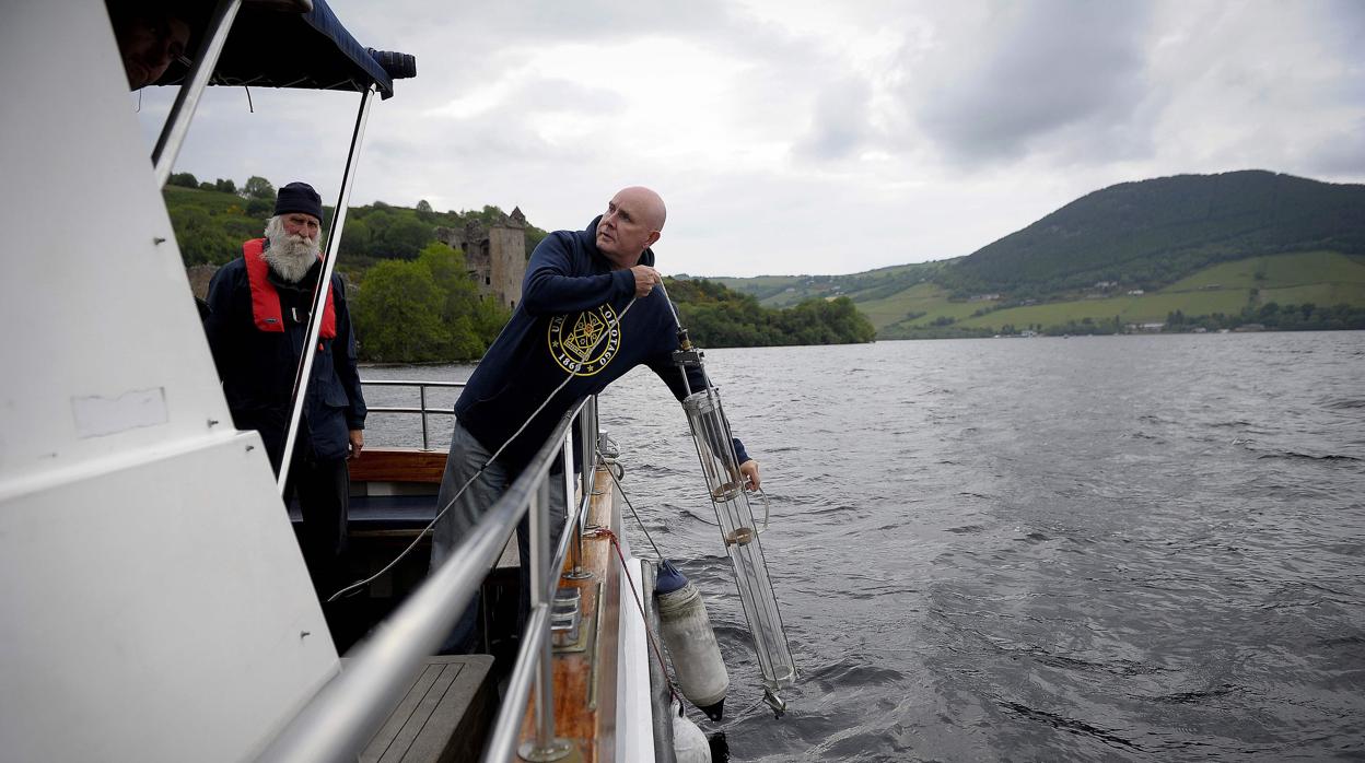 Neil Gemmell (derecha) extrae muestas de agua para secuenciar el ADN