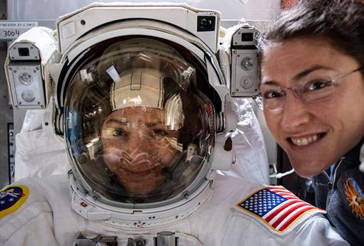 La astronauta Christina Koch (derecha) posa con su compañera Jessica Meir (izquierda), dentro de un traje espacial