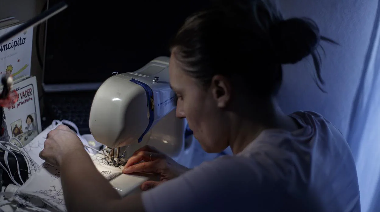 Una mujer cose una mascarilla con una máquina de coser dentro de una iniciativa de un grupo de amigas que donará mascarillas para la protección frente al coronavirus