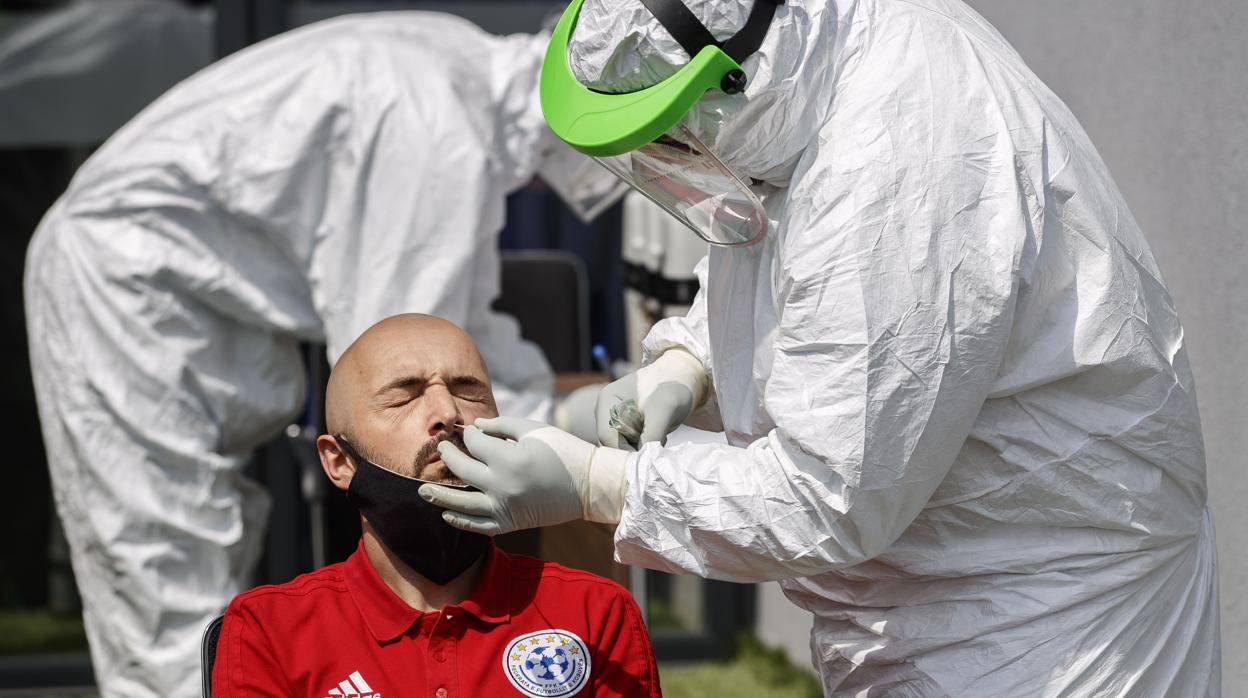 Dos técnicos le hacen una prueba de coronavirus a un árbitro en Pristina, Kosovo, el pasado 30 de mayo