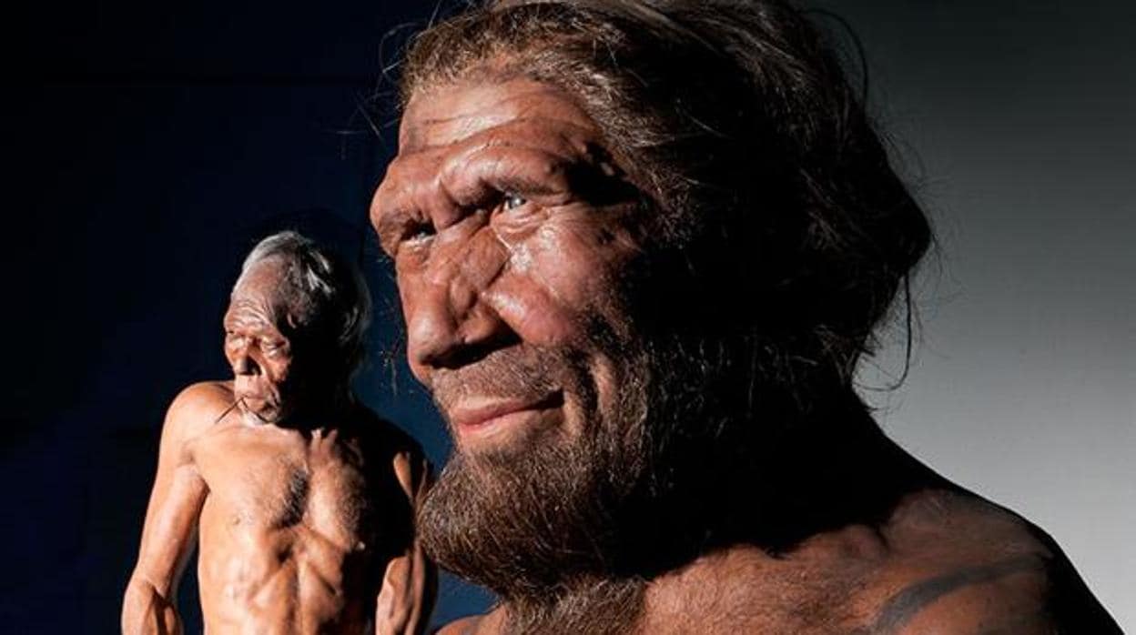 En primer plano, representación de un neandertal. Al fondo a la izquierda, un sapien