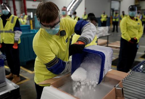 Empleados introducen hielo seco en una caja para transportar viales de la vacuna de Pfizer/BioNTech en la planta de Kalamazoo, en Michigan (EE.UU.), el pasado domingo