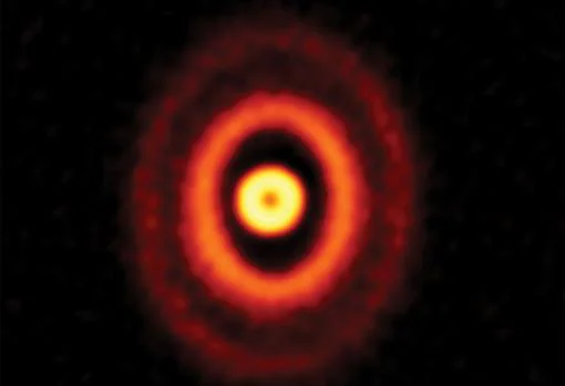 Tres anillos brillantes de color naranja giran alrededor del extraño sistema estelar triple GW Orionis