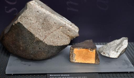 Imagen de los tres fragmentos del meteorito de Reliegos que posee el MNCN. El del centro, en el que se puede ver una etiqueta descriptiva, es el recientemente recuperado por la Guardia Civil