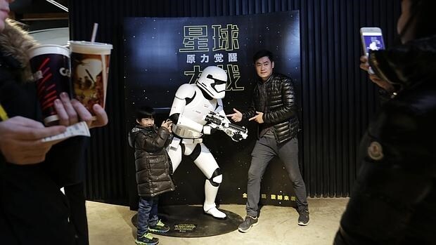 Dos espectadores posan ante una figura de «La guerra de las galaxias» en un cine de Pekín