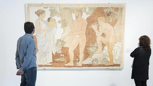 Dos personas contemplan «La Tierra, Eneas y Pan», un fresco que Torres-García pintó para la casa que se construyó en Tarrasa