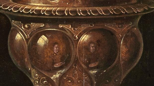 Dos autorretratos de Clara Peeters reflejados en una copa dorada pintada en el cuadro «Bodegón con flores, copas doradas, monedas y conchas»