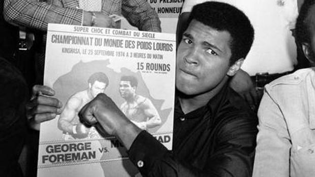 Mohamed Alí muestra en septiembre de 1974 el cartel donde se anuncia el combate de los pesos pesados en el que, un mes más tarde, derrotaría a George Foreman