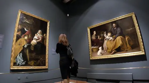 Una mujer admira «La Adoración de los Magos, de Velázquez (a la izquierda) y «La Sagrada Familia del pajarito», de Murillo