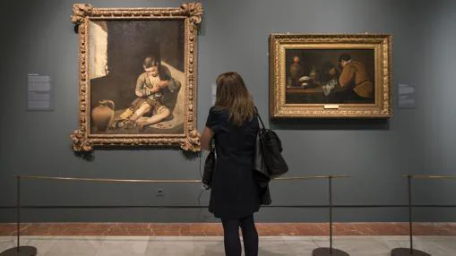 Una joven contempla «Niño espulgándose», de Murillo (a la izquierda) y «Dos jóvenes a la mesa», de Velázquez