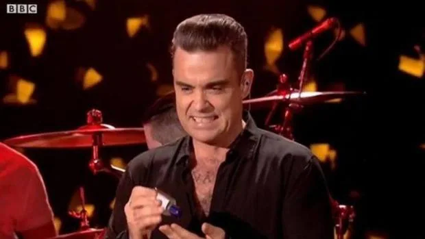 Robbie Williams en el momento de echarse el gel