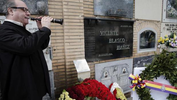 Un músico interpreta una pieza musical ante el nicho del escritor Vicente Blasco Ibañez, en el cementerio general de Valencia