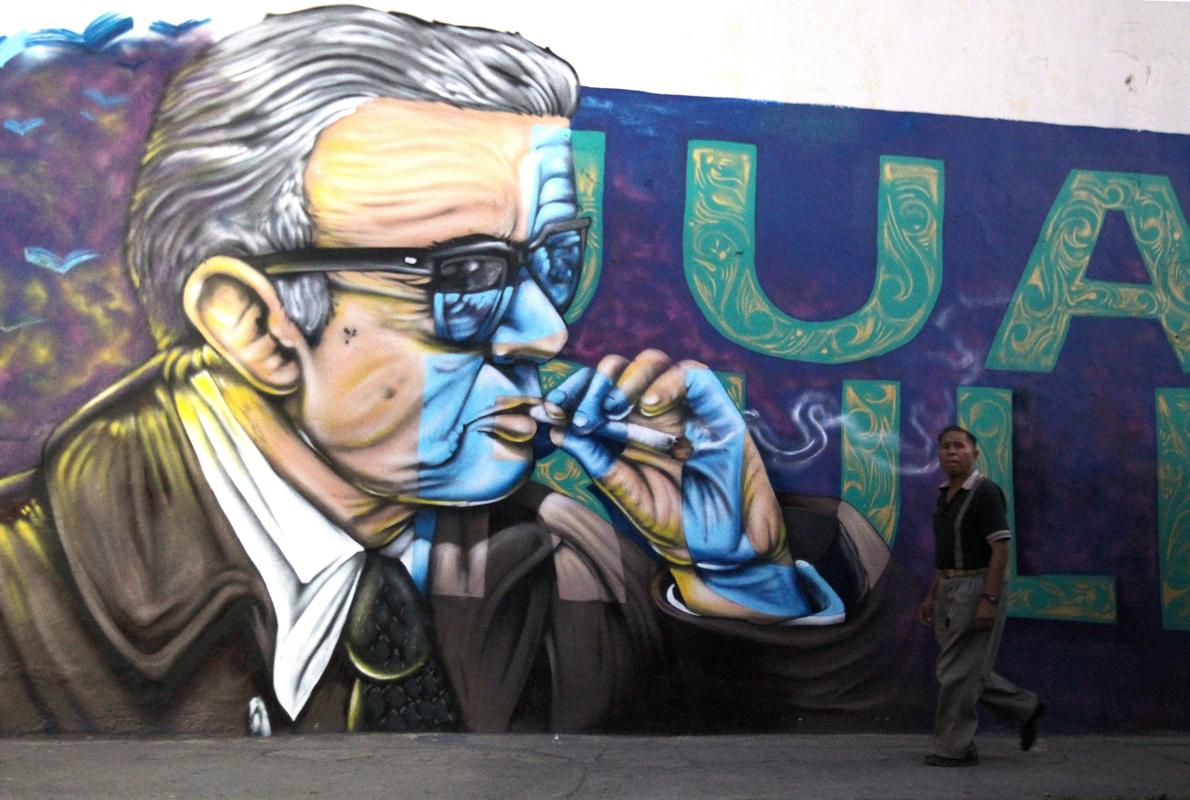 Un hombre pasa por delante de un mural con una imagen de Juan Rulfo en el municipio de Tuxcacuesco