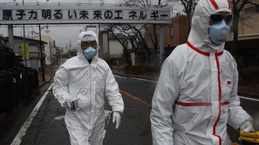Midiendo la radiación en Futaba, uno de los pueblos evacuados alrededor de la central de Fukushima 1. «La energía nuclear es el motor de nuestro brillante futuro», reza el letrero del fondo.