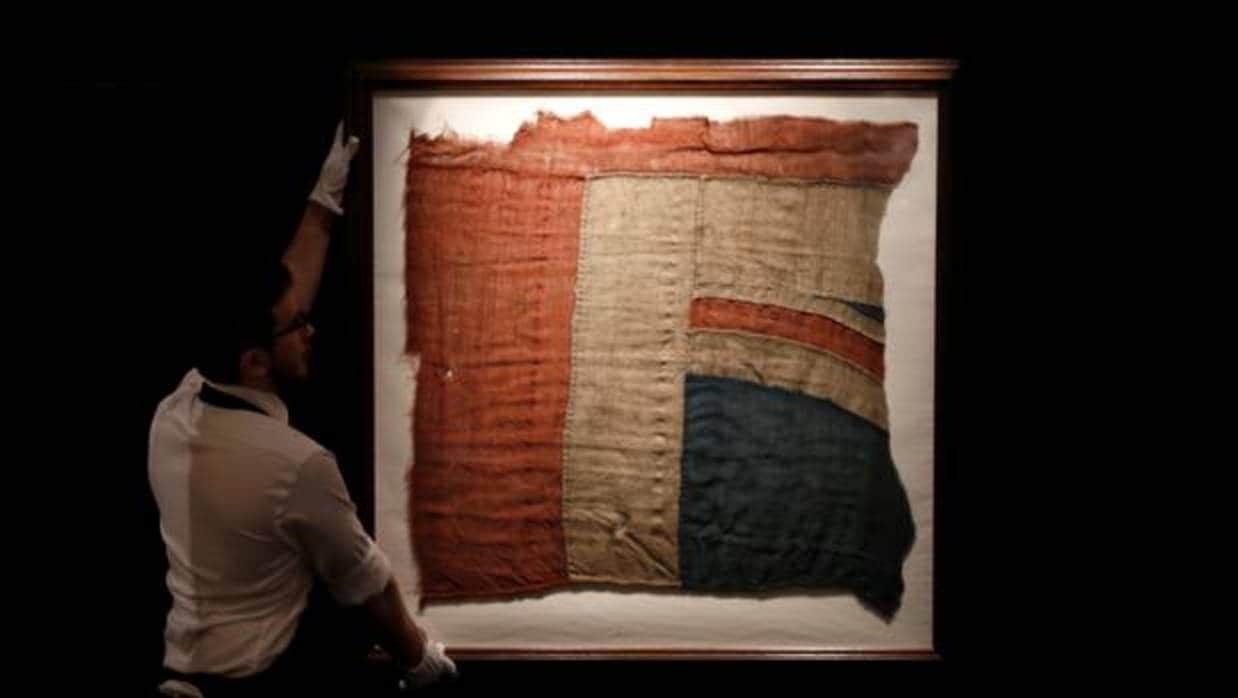 Un empleado de Sotheby's muestra el fragmento de la bandera que Nelson ondeó en Trafalgar