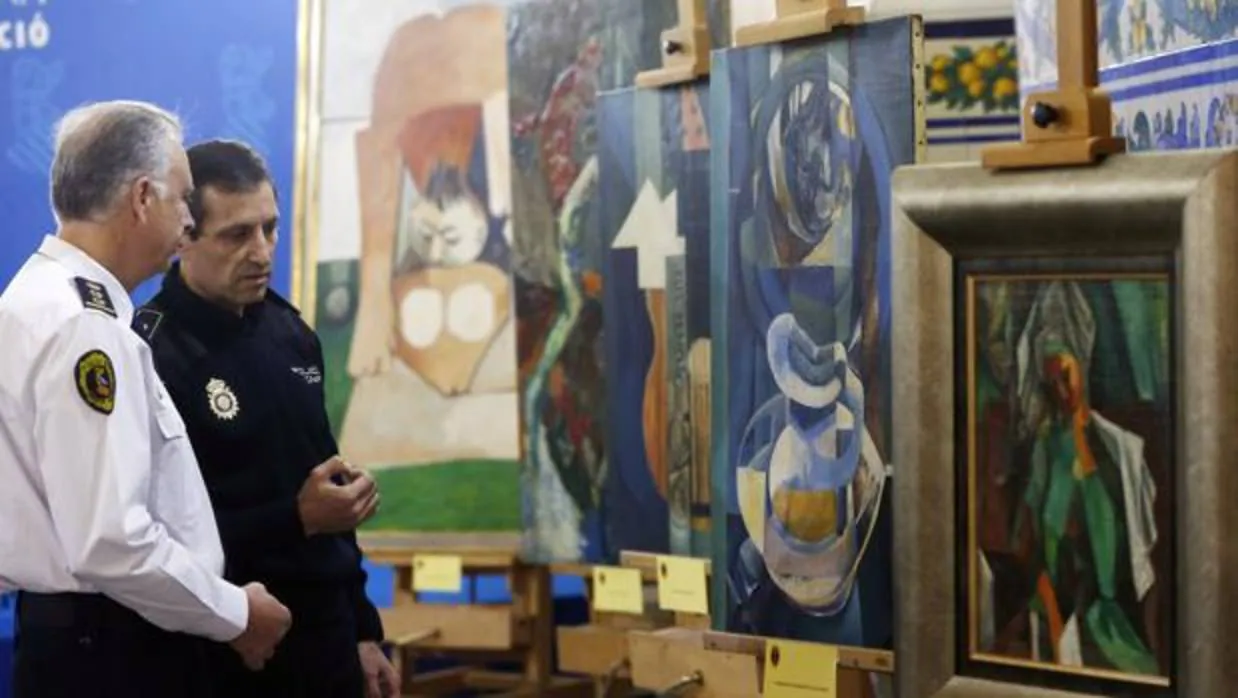 Imagen de archivo. Un policía nacional y un policía autonómico conversan ante las obras falsas de Picasso que iban a venderse de forma ilícita en 2015
