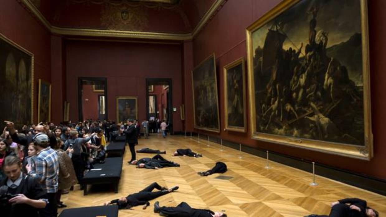 Los activistas, tirados en el suelo junto a «La balsa de la medusa» en una sala del Louvre