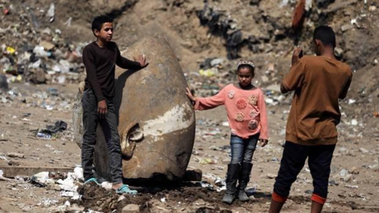 Foto de archivo: dos niños posan junto a la cabeza recuperada de la estatua de Psamético I en marzo de 2017