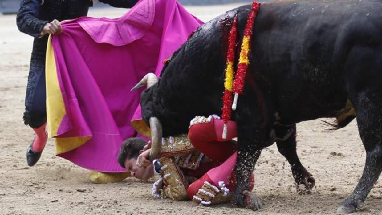 Espeluznante imagen, con Rafael González intentando zafarse del novillo, con el pitón en la cara