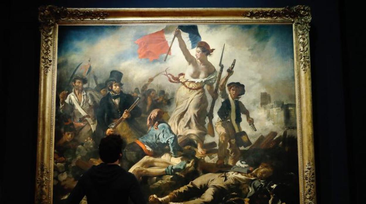 Un hombre mirando «La Libertad guiando al pueblo» durante la exposición de Delacroix