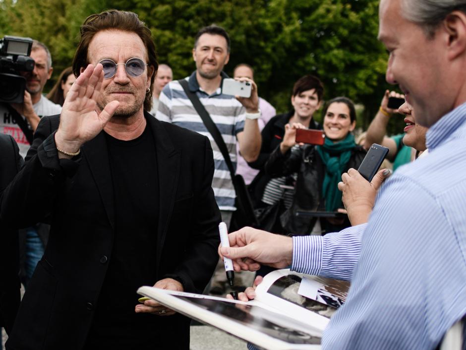 Bono, líder de U2, atiende a sus fans poco después de reunirse con la canciller alemana Angela Merkel en Berlín