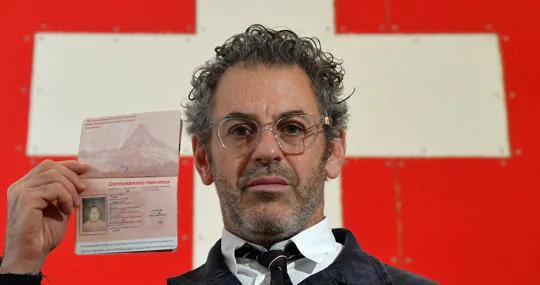 El americano Tom Sachs posa con un pasaporte suizo, parte de su instalación en Frieze
