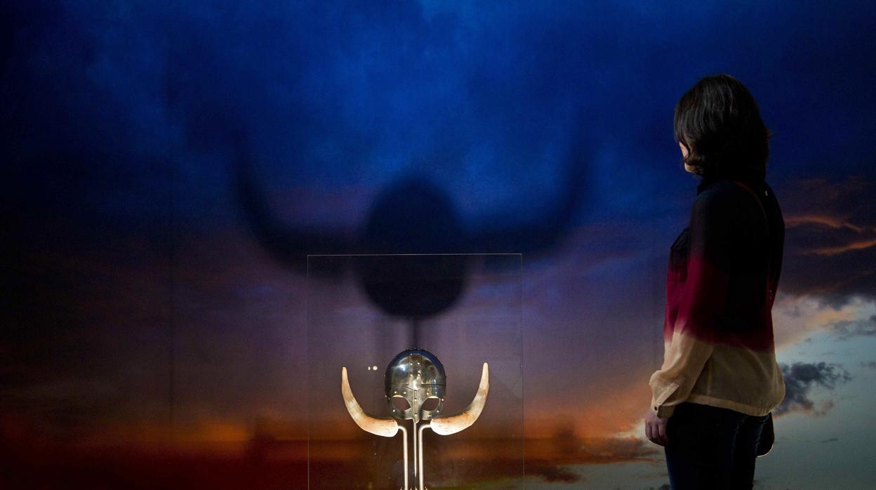 Una mujer observa una réplica de un casco vikingo en la exposición «Vikings» de 2014