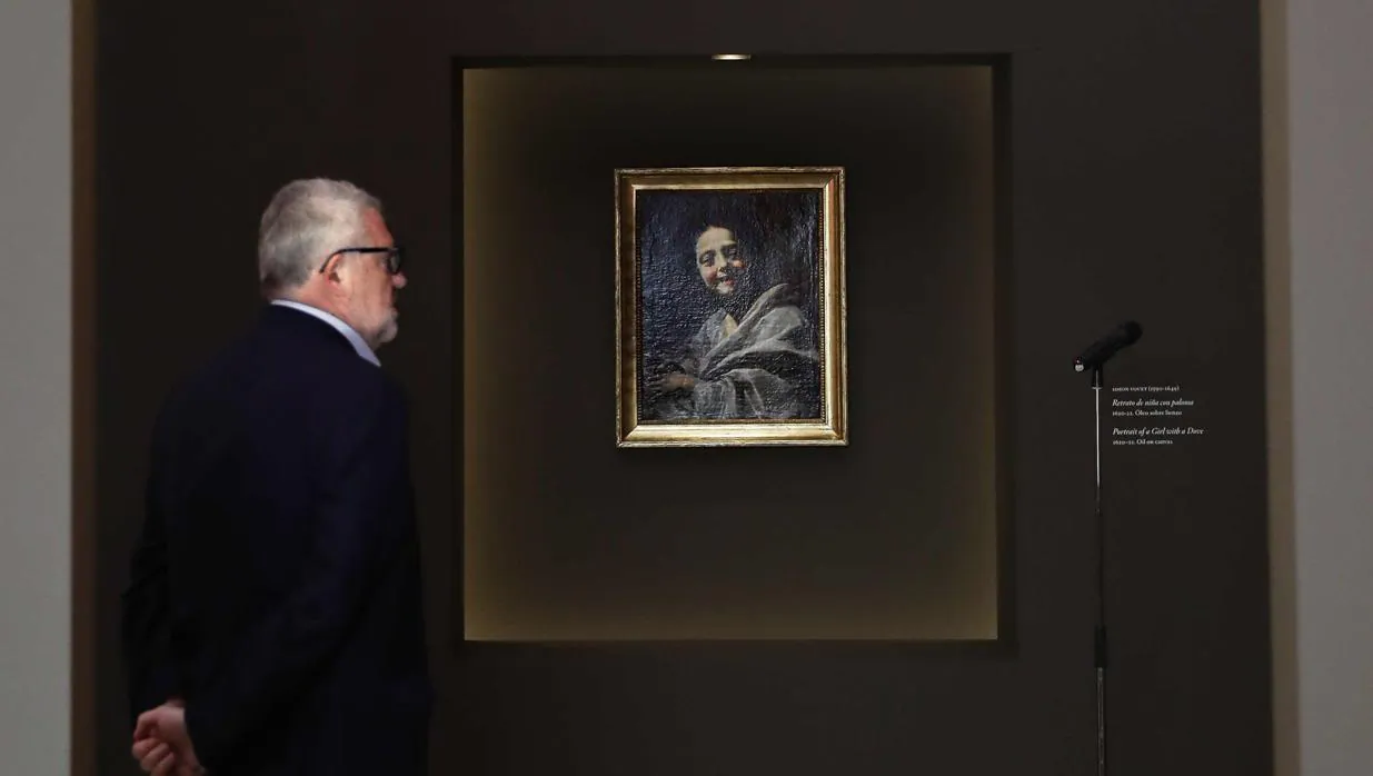 El director del Prado, Miguel Falomir, mira con atención el cuadro de Vouet «Retrato de niña con paloma»