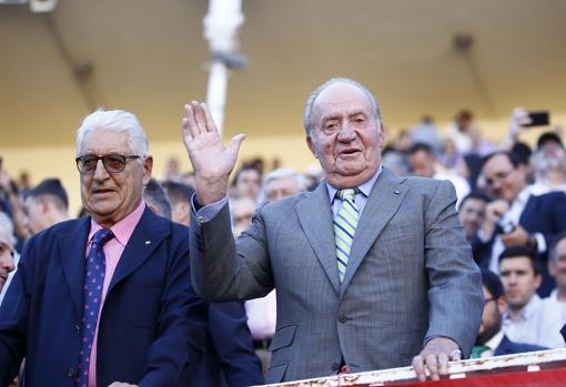 Don Juan Carlos, con Manolo Piñera, saluda desde la meseta de toriles