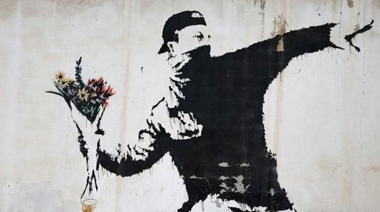 Obra de Banksy en la que un manifestante protesta con un ramo de flores