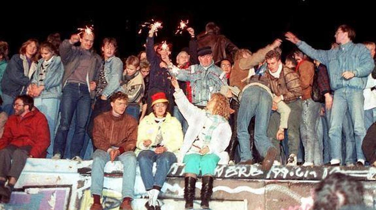 Ciudadanos alemanes encaramados al Muro de Berlín el 9 de noviembre de 1989