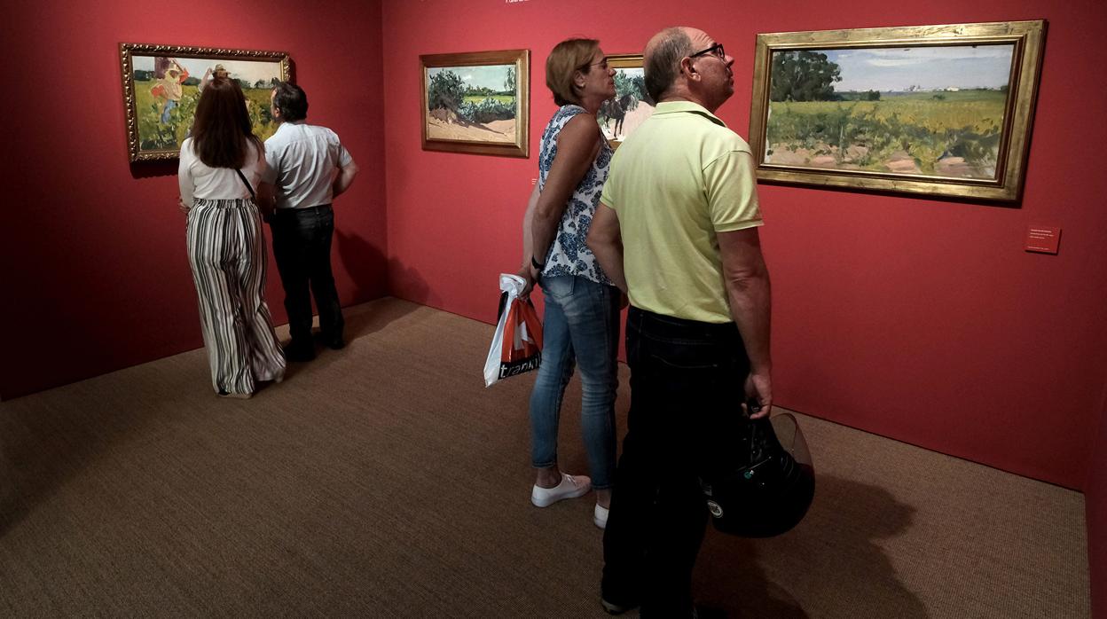 Visitantes contemplan las obras de Sorolla en la exposición de Unicaja